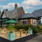 The exterior facade of the venue with hanging baskets, wooden benches and planters at The Church View Inn.