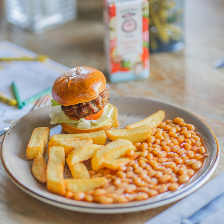 A young guests beef burger served with baked beans and chips available at Chef and Brewer venues.