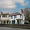 The exterior facade and signage of The White Lion, with a low stone wall in front of the building.