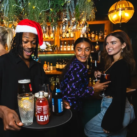 A man with a tray of drinks in the pub