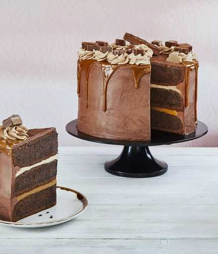 a cake on a stand next to a slice of it on a plate