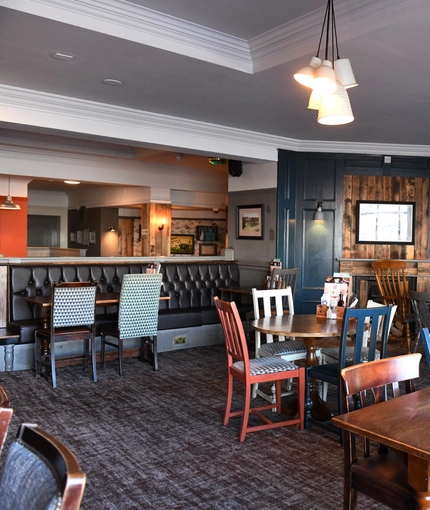 Interior dining area of a pub with a TV.