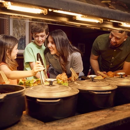 A family choosing a selection of foods for a carvery at the carvery deck.