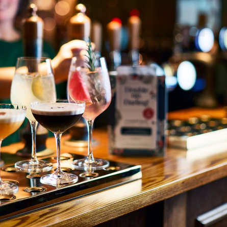 A 1483x834 sized Web Homepage Promo banner showing 4 cocktail style drinks sat on an interior bar to advertise a 2 for £12 cocktail spring offer at Chef & Brewer venues.