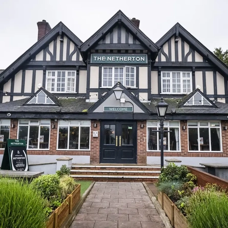 Exterior facade of a pub with a seating area.