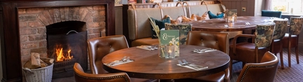 Some tables near a fireplace in the restaurant of Himley House.
