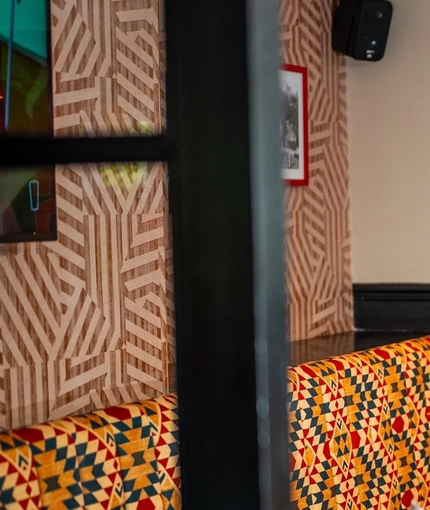 An interior restaurant seating area at The Bramford Arms, with an upholstered booth seat along one side of the room, and the words "Skills on the Grills" on the wall in red and black lettering.