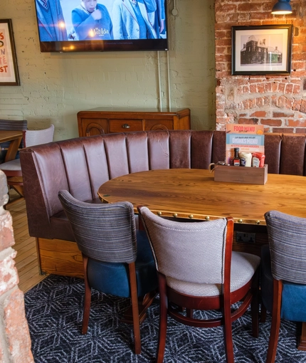 An image of one of the tables within the interior restaurant seating area and TV at The Guild.