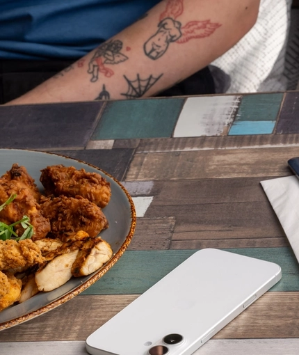 A Chicken Sharer on a table with hands holding a pint of Level Head and a glass of wine.
