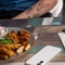 A Chicken Sharer on a table with hands holding a pint of Level Head and a glass of wine.