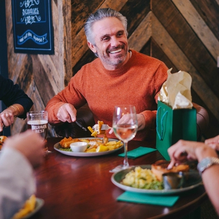 A family out for a meal for Fathers day seated in the interior restaurant of a Greene King pub.
