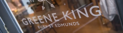 A window in a door that says Greene King