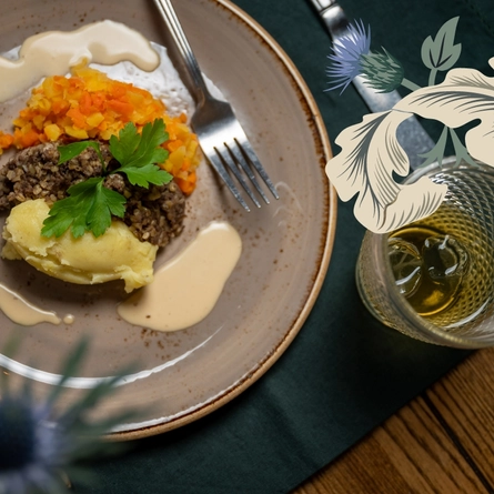 Haggis, Neeps and tatties. Plated with a whisky sauce drizzled over it. With a whiskey on the side.