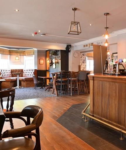 Interior dining area of a pub with a bar and a TV.