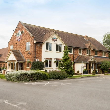 Exterior facade of a pub with a car park.