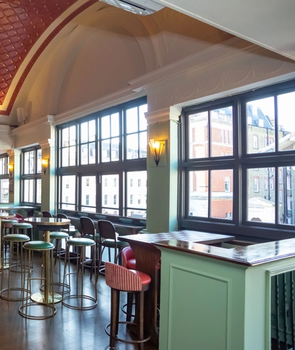 Interior of bar with high tables and bar stools surrounding