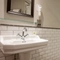 The interior hotel bathroom with a sink, mirror and shower at the Cedars Inn.