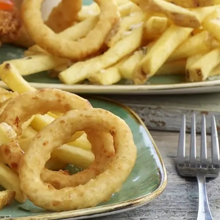 Three plates of burger, chips and onion rings
