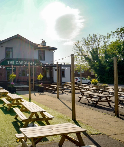 Exterior facade and beer garden of a pub with a seating area.