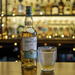 A bottle and poured glass of Glenlivet Whiskey.