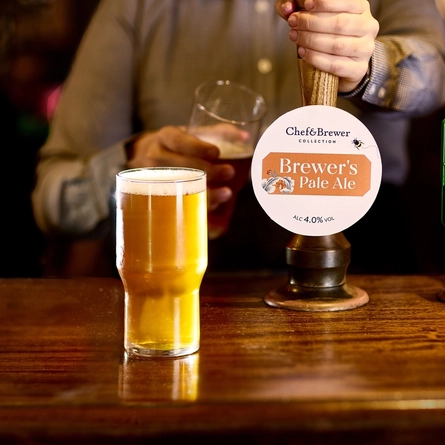 An image of a pint of Brewers Pale Ale sat on the interior bar with a member of staff pouring a pint in the background at a Chef & Brewer venue.