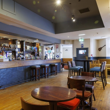The interior bar and seating area with guitar wall decor at The Burnett Arms.