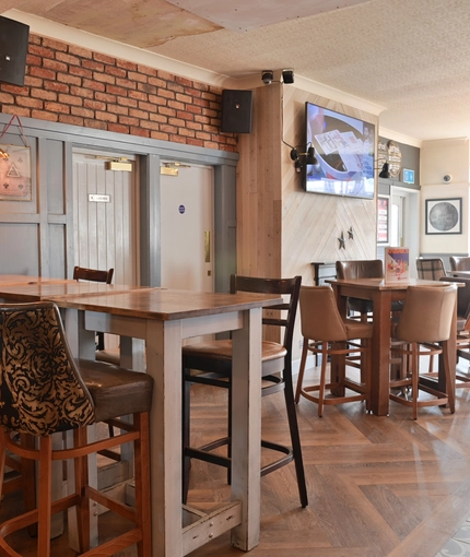 Interior dining area of a pub with a TV.