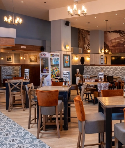 The interior restaurant seating area at The Wrekin Giant in Telford, with upholstered booth seats, and TVs on the walls.