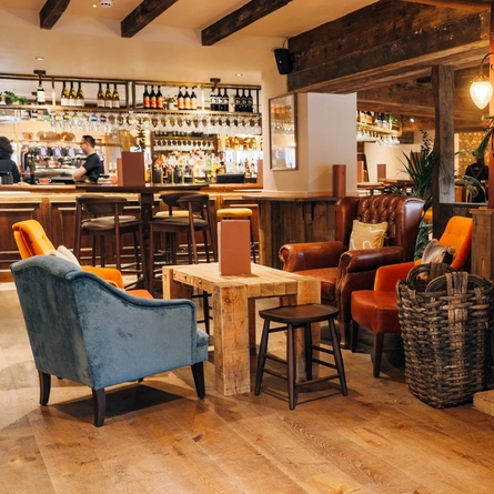 interior dining area of a pub with a bar and a fireplace
