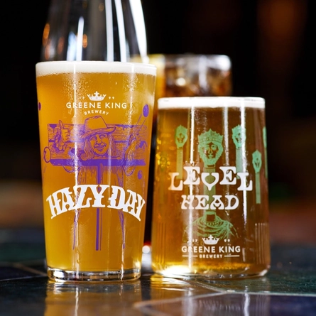 A pint of Hazy Day and Level Head on a bar.