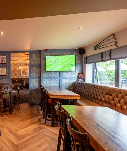 Interior dining area of a pub with a TV and a few gambling machines.