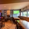 Interior dining area of a pub with a TV and a few gambling machines.