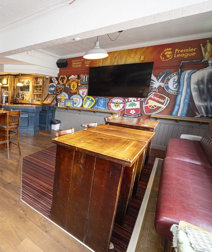 Interior dining area of a pub with a few TVs.