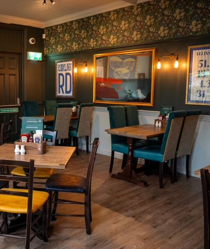 An interior restaurant seating area at The Grosvenor, with framed artwork on the walls.