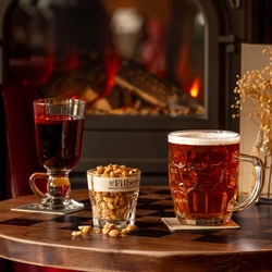A glass of mulled wine and a cask ale served by the fire at The Three tuns.