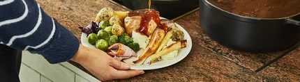 A full carvery plate with gravy being poured
