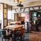 Interior seating area of a pub with a TV, a fireplace, a pool table and a gambling machine.