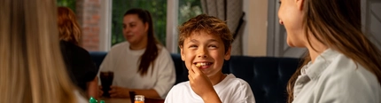 A family sat at an indoor table enjoying a meal and drinks at a Hungry Horse venue.