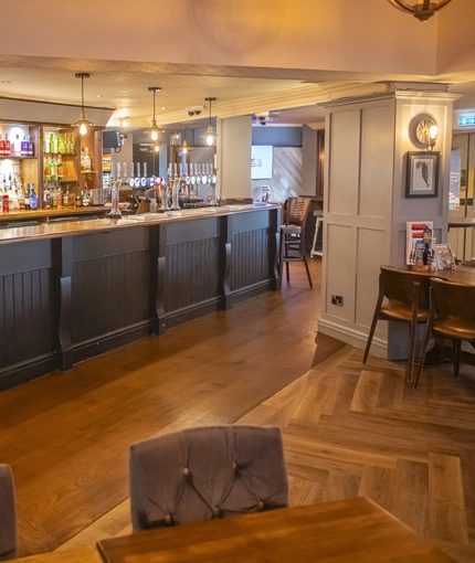 Interior dining area of a pub with a bar.