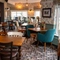 An interior restaurant seating area at the Devonshire Arms, with framed artwork on the walls.