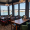 The interior restaurant seating area with tables, chairs and a seaview from the window at The Spice Island.