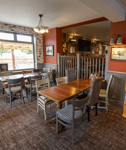 Interior dining area of a pub with a TV and a few toy vending machines.