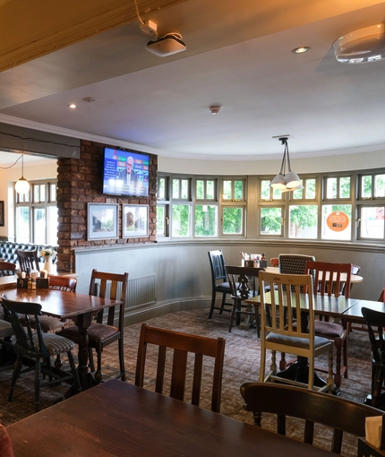 Interior dining area of a pub with a TV.