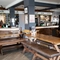Interior dining area of a pub with a bar and a gambling machine.