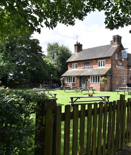 The exterior of The Peacock Inn, and part of its beer garden.