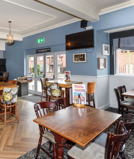 Interior dining area of a pub with a few TVs.