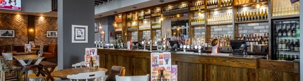 A bar with tables and chairs in the foreground.