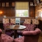 The wood panelled interior restaurant seating area at The Fox, with upholstered chairs, and framed artwork on the walls.