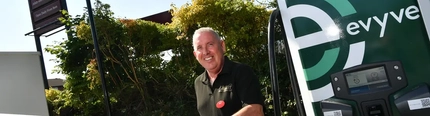 A Greene King colleague using the EV chargers in a car park.