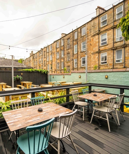 The exterior beer garden and seating area with benches and tables and chairs at the Armstrongs.